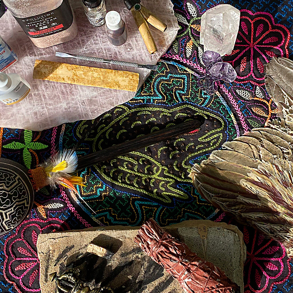 "Transpersonal empowerment tools with feathers, crystals, and smudge sticks for kambo healing and plant medicine retreats."